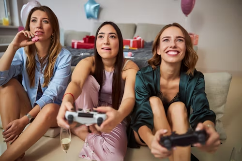 Three women playing video games, representing shared digital experiences and entertainment.