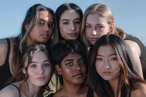 A close-up of diverse women's faces, representing the anonymous yet connected community.
